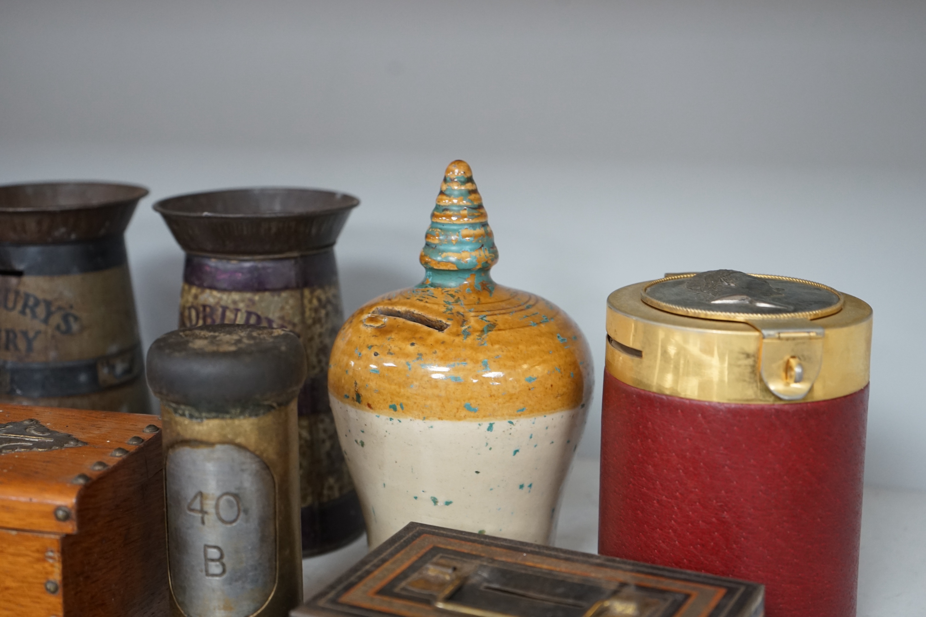 A collection of mixed tin wood and ceramic money boxes to include Cadbury’s milk chocolate, three in the form of trunks and a ceramic pig. Condition - varies